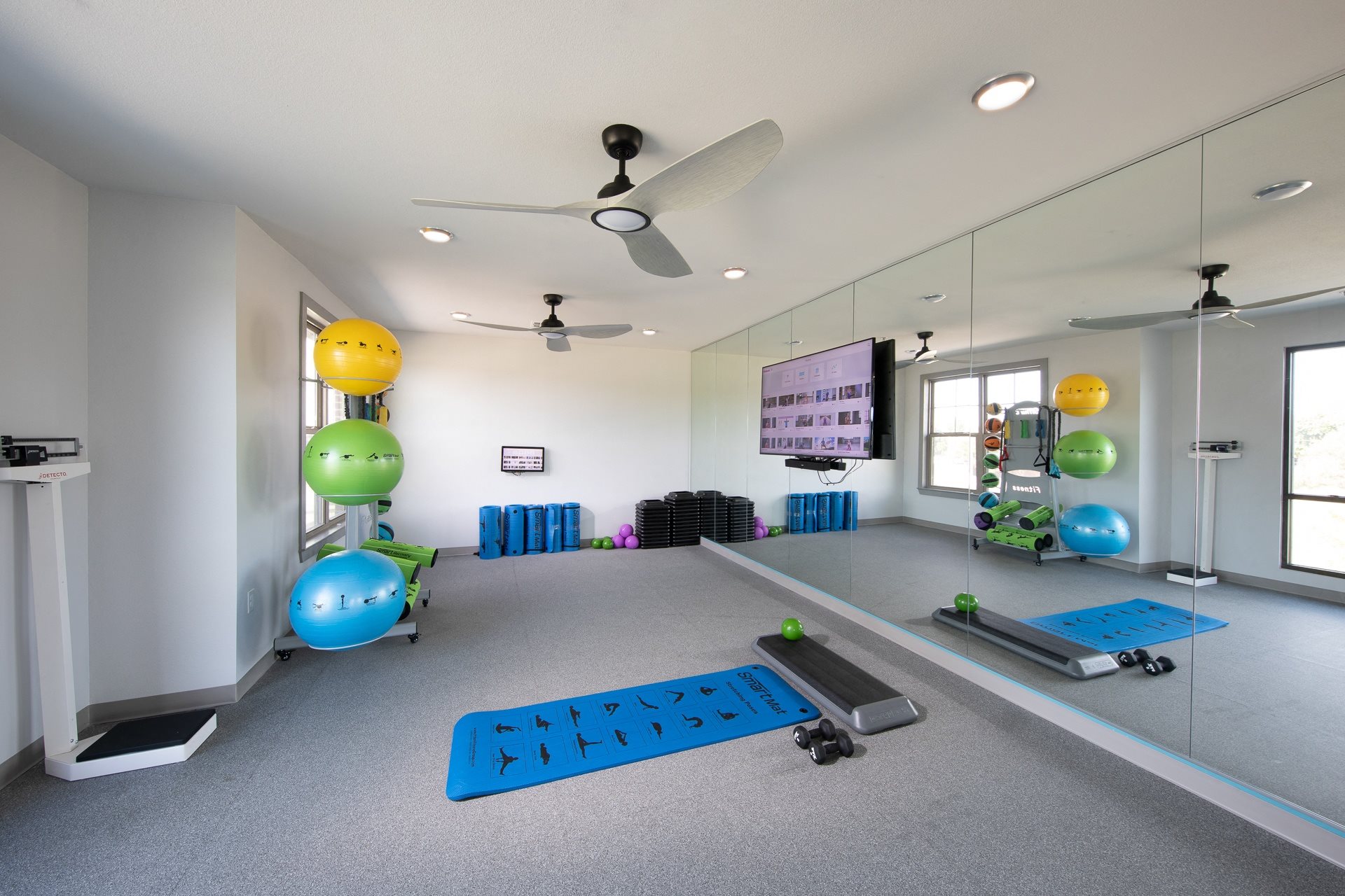 a fitness room with yoga mats and workout equipment at a senior apartment community